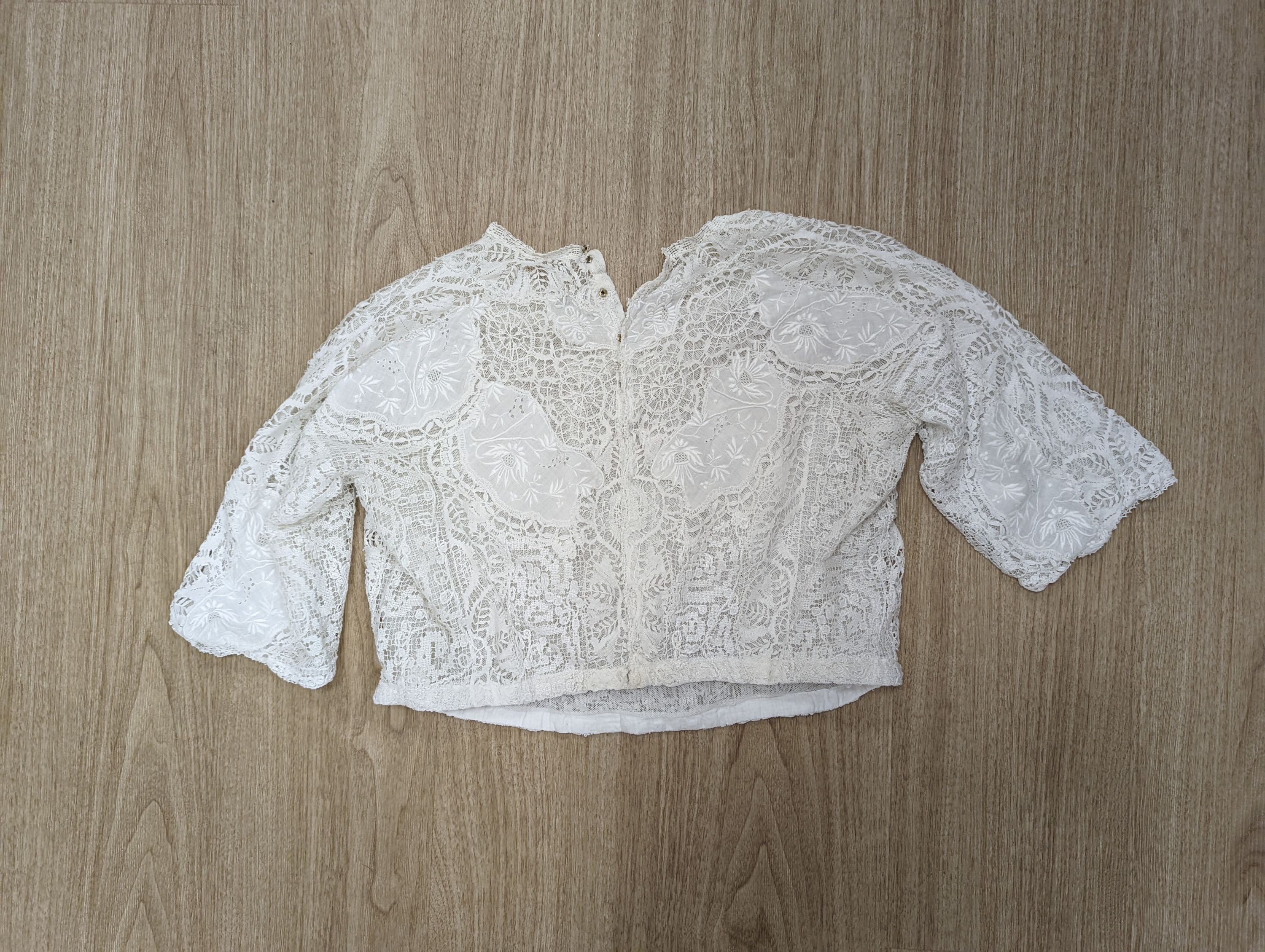 A 19th century hand made Irish crochet jacket, with long sleeves and high collar, a bobbin lace and white worked patch worked blouse, a fine lawn and anglaise worked blouse and a fine bobbin lace trimmed and white worked